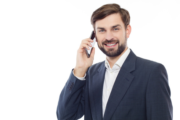 Knappe zakenman praten aan de telefoon en lacht, geïsoleerd - Foto, afbeelding