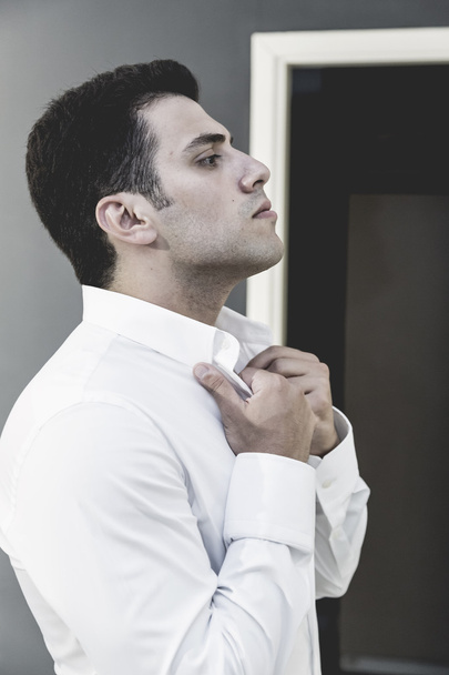 attraktiver junger Mann im weißen Hemd Studioaufnahme, männliches Modell auf dunkelgrauem Hintergrund - Foto, Bild