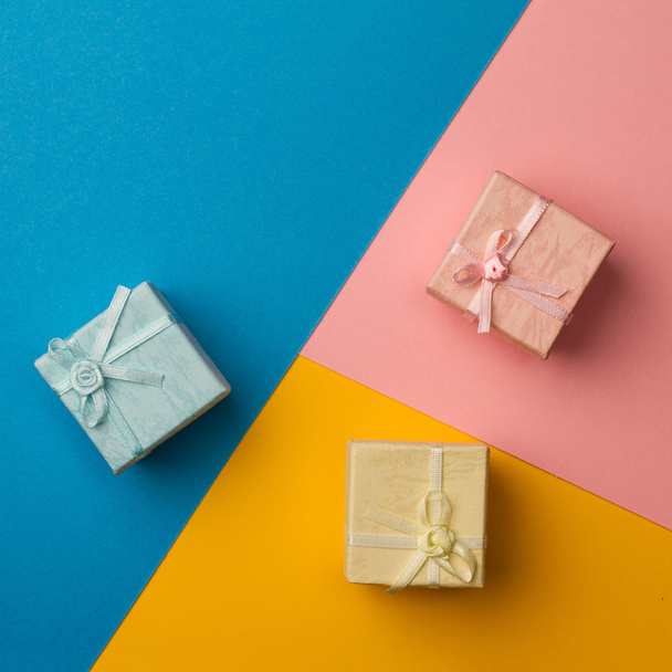 small gift boxes on multicolored paper background - Foto, Imagen