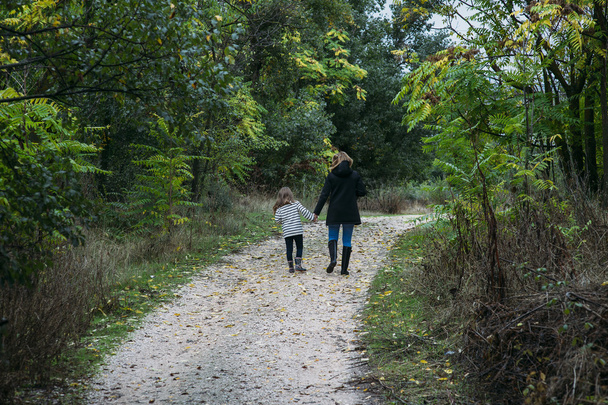 madre caminando con hija en el campo
 - Foto, Imagen