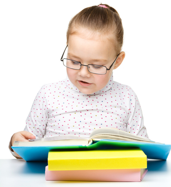 schattig klein meisje het lezen van boek dragen van een bril - Foto, afbeelding