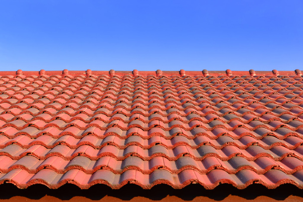 de rode keramische dakpan met zonlicht en de blauwe hemel - Foto, afbeelding