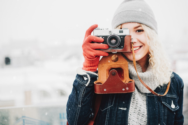 Smiling curly blond girl with retro film camera - Photo, Image