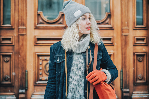 Young blond curly girl with red gloves and bag, winter - Фото, зображення