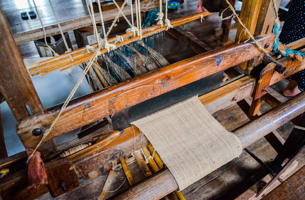 Cierre de hilos de bambú tejiendo en el telar de madera manual
 - Foto, imagen