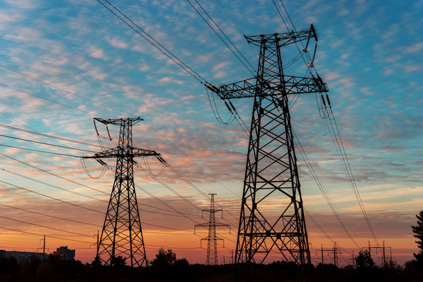 Elektriciteit pylonen en lijnen in de schemering bij zonsondergang. - Foto, afbeelding