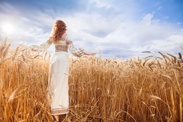 Csinos nő öltözve, hímzett blúz búza területén - Fotó, kép