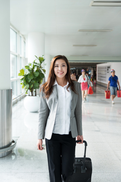 азіатська молода дівчина з багажем в аеропорту
  - Фото, зображення