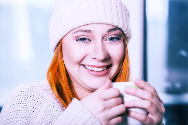 Woman wearing warm clothing and drinking hot drink - Fotografie, Obrázek
