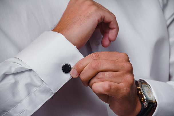 primer plano de una mano hombre lleva camisa blanca y gemelo
 - Foto, imagen