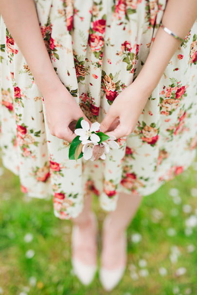 girl holding sakura cherry blossom in hands - Fotoğraf, Görsel