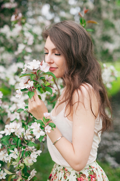 女の子のスニッフィング桜の花 - 写真・画像