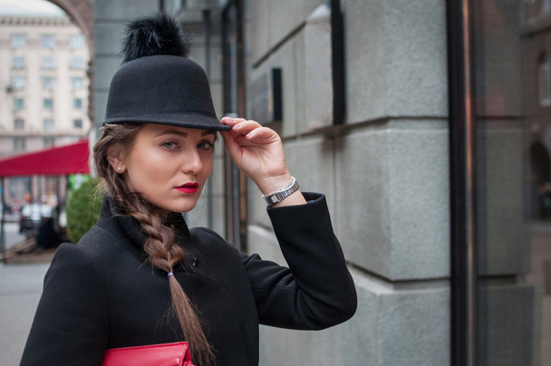 Mooi meisje met rode tas, het dragen van een zwarte hoed en leath - Foto, afbeelding