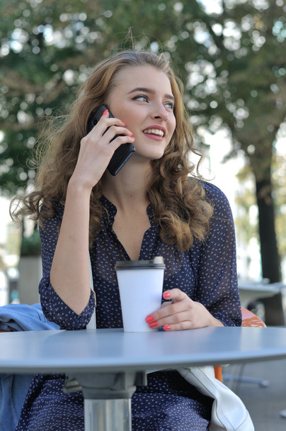 Beautiful girl with long hair talking on a cell phone - Valokuva, kuva