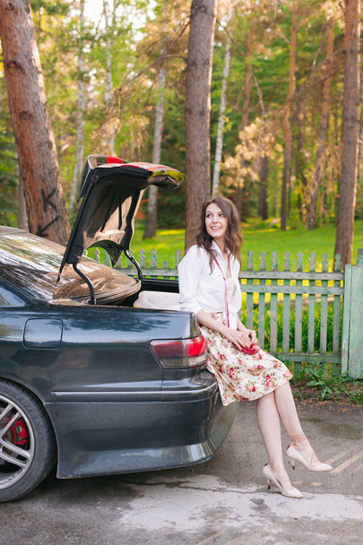 Araba bagajında oturan genç kadın  - Fotoğraf, Görsel