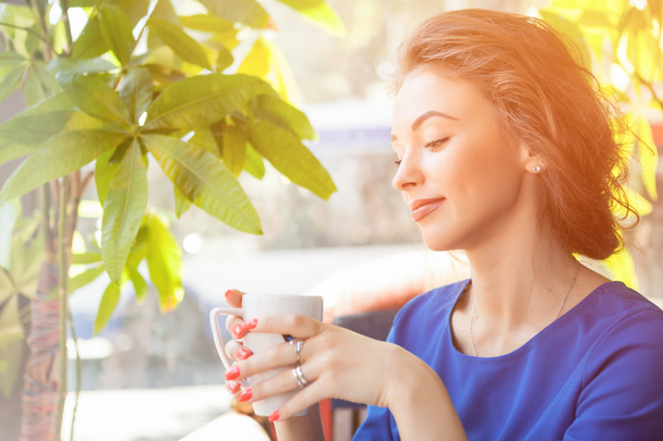 Beautiful woman enjoying a cup of coffe - Foto, imagen