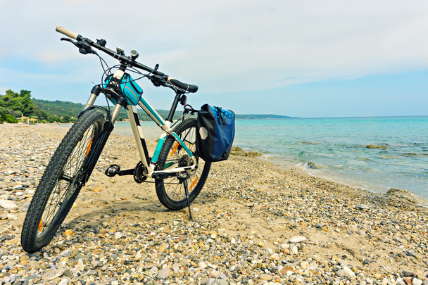 Pysäköity rannalla maastopyörä odottaa jatkoa
  - Valokuva, kuva