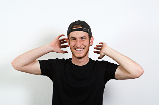 Joyful and Smiling Happy Young Adult Male in Dark T-Shirt and Baseball Hat Worn Backwards - Fotoğraf, Görsel