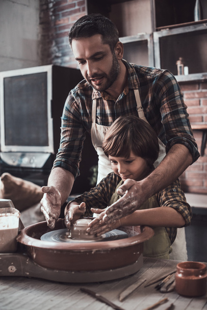 father and son making ceramic pot - Foto, afbeelding