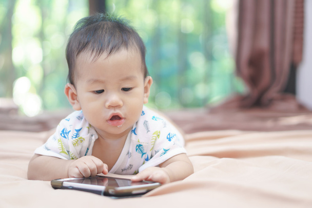 Asiático bebê jogando telefone celular
 - Foto, Imagem