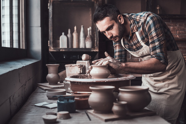 man in apron making ceramic jug  - Φωτογραφία, εικόνα