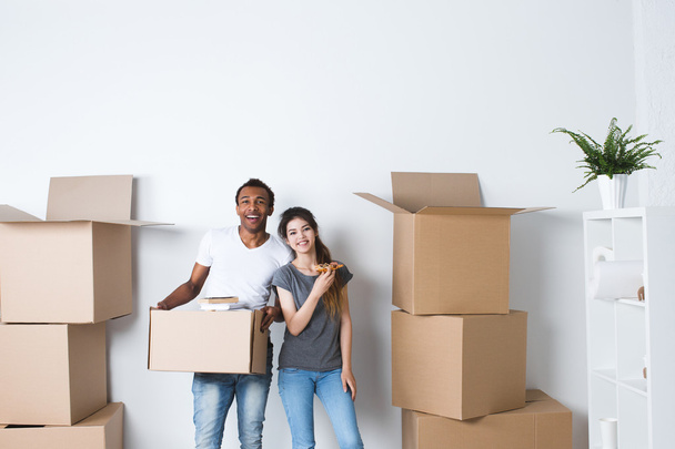 Smiling couple unpack boxes in new home. - 写真・画像