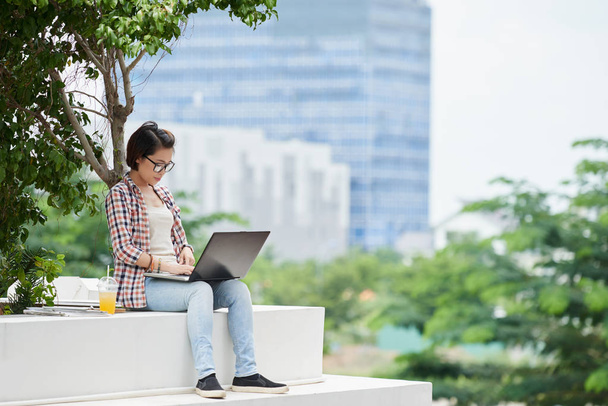 женщина с ноутбуком наслаждается работой на открытом воздухе
 - Фото, изображение
