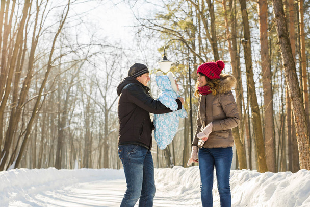 батьківство, сезон і концепція людей щаслива сім'я з дитиною в зимовому одязі на відкритому повітрі
 - Фото, зображення