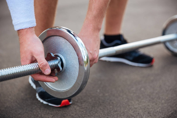 Muscular fitness man going to lift heavy barbell - Foto, Imagem