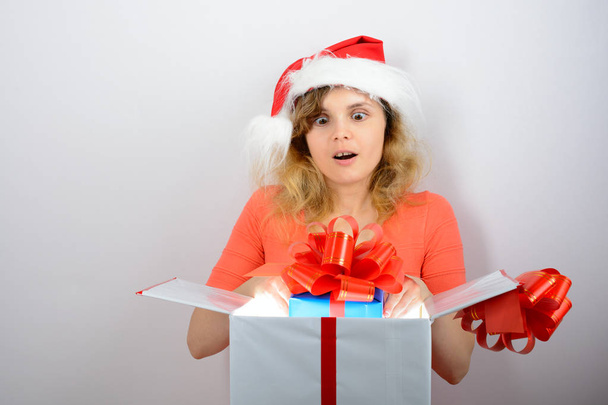 Ragazza in cappello di Babbo Natale aprire una scatola
 - Foto, immagini