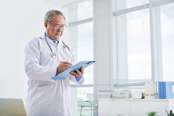 mature doctor with folder - Photo, Image