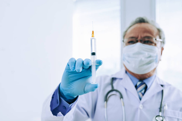 Médecin avec seringue pleine de médicaments
 - Photo, image