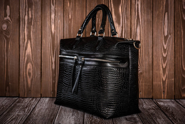 black leather bag on brown wooden background. - Fotografie, Obrázek