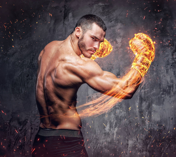 Combatiente sin camisa con guantes de boxeador en llamas
. - Foto, imagen