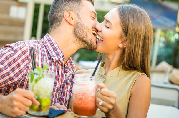 Симпатичный мужчина целует молодую женщину в модном коктейль-баре - Счастливая пара влюбленных в начале любовной истории - Концепция чувств с парнем и девушкой на теплом отфильтрованном взгляде - Фокус на губах
 - Фото, изображение