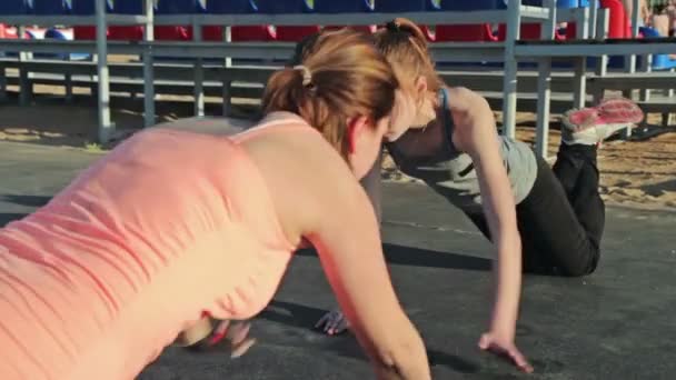 Two young women doing push-ups - Πλάνα, βίντεο