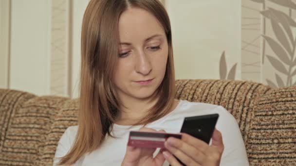 Νεαρή γυναίκα καυκάσιος που αγοράζουν αγαθά από το internet στο έξυπνο τηλέφωνό της - Πλάνα, βίντεο