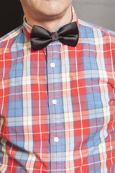 Man Dressed Checkered Shirt With Black Bow Tie On Gray - Foto, Bild