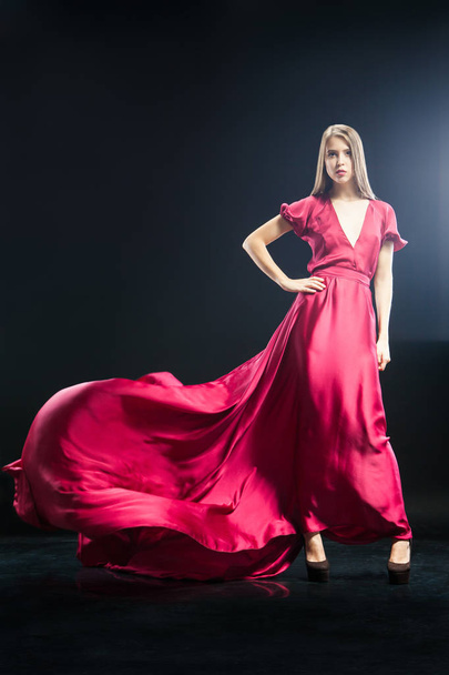 Attractive young woman in elegant long pink dress - 写真・画像