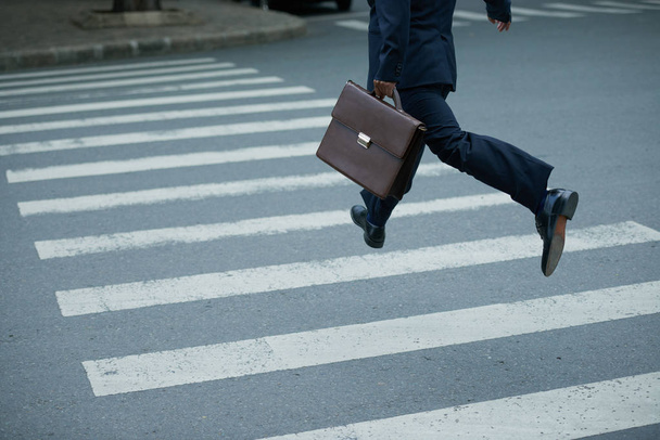 Uomo d'affari con valigetta fretta di attraversare la strada
 - Foto, immagini