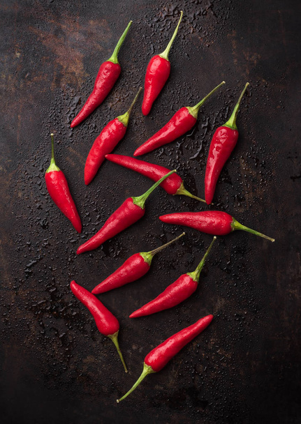 Syrové červené chilli papričky na černé rezavé stůl - Fotografie, Obrázek