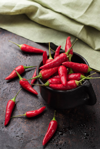 Raw red chili peppers on a black rusty table - Photo, Image