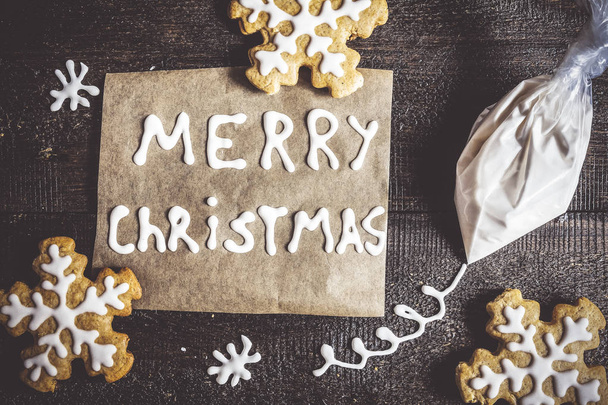 Pan de jengibre de Navidad, inscripción y una bolsa de azúcar glaseado en un
 - Foto, Imagen