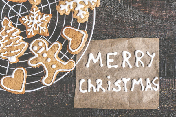 Galletas de jengibre de Navidad e inscripción en un fondo oscuro
 - Foto, Imagen
