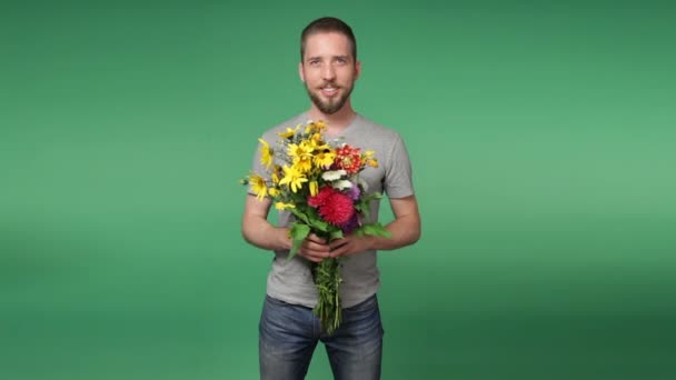 Young romantic man giving a bouquet of flowers - Materiał filmowy, wideo