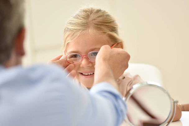 girl at the optician trying eyeglasses  - Foto, Bild