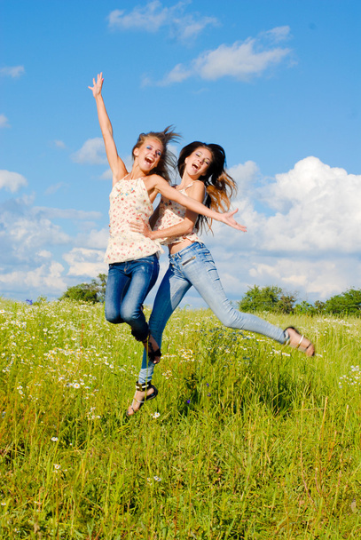 Two happy young women jumping - Fotoğraf, Görsel