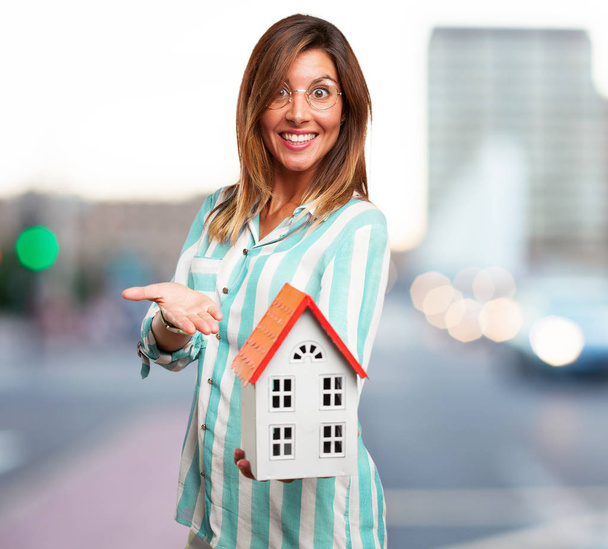 happy young woman with house - Foto, afbeelding