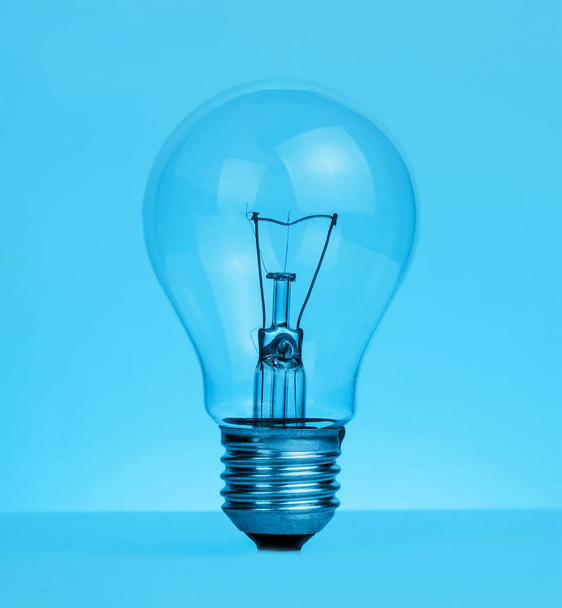 retro vintage light bulb with on blue tint background - Zdjęcie, obraz
