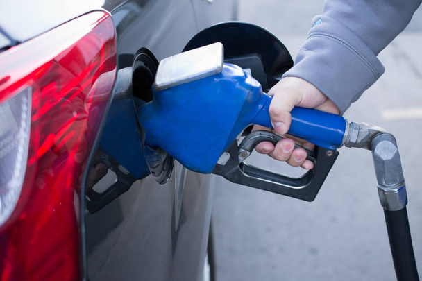Pumping gas at gas pump. Closeup of man pumping gasoline fuel in - Valokuva, kuva